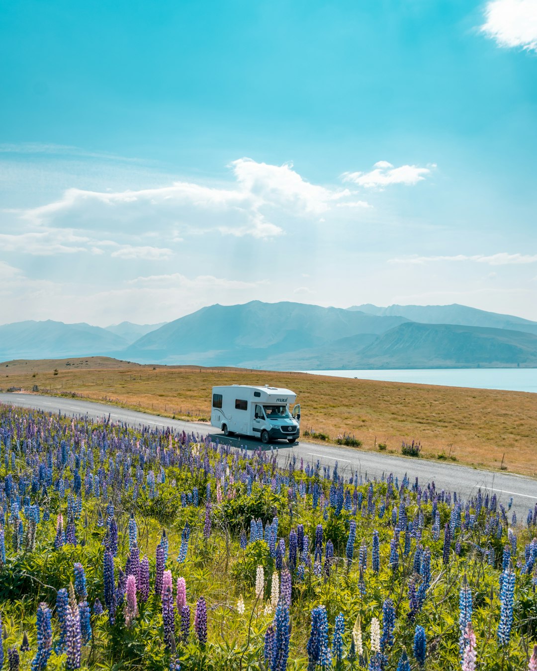white-van-on-road-near-green-grass-field-during-daytime-m5z-a70sn6e